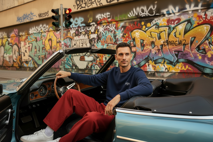 European man in vintage convertible with red trousers